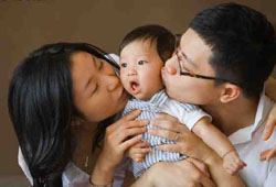 Родители целуют ребенка